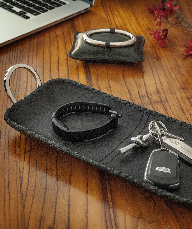 keys and watch black resting on 14 inch length leather tray
