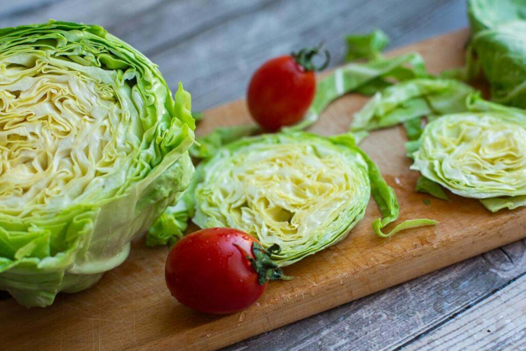 Iceberg lettuce and cherry tomatoes on a cutting board