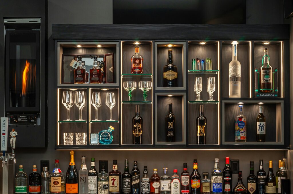 Alcohol bottles and glasses on a wooden shelf