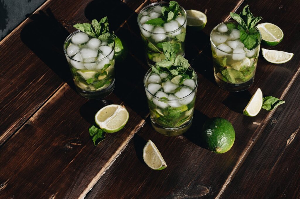 Four mojito mocktails on a wooden table