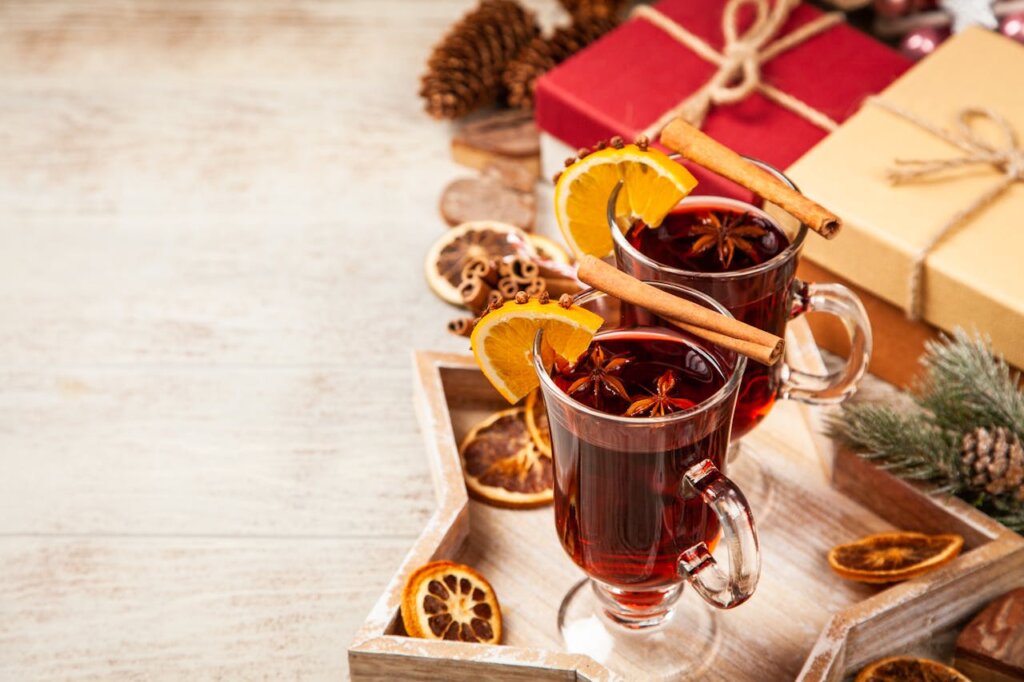 Two gin hot toddies next to holiday gifts