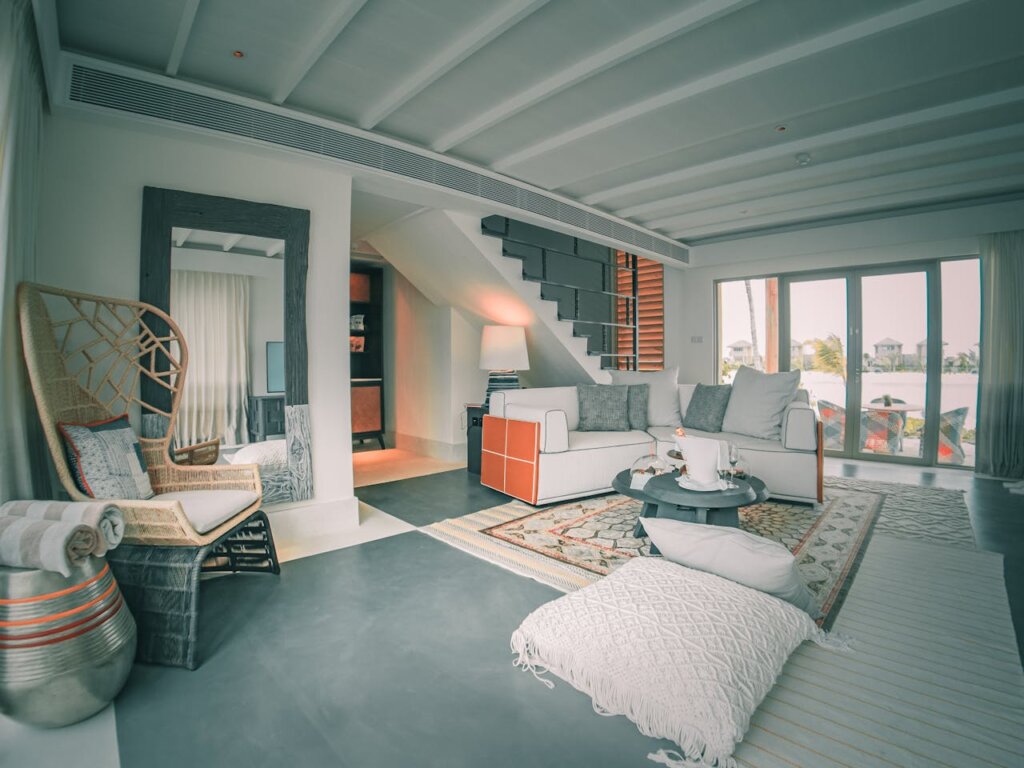 A grey and white living room with pops of orange