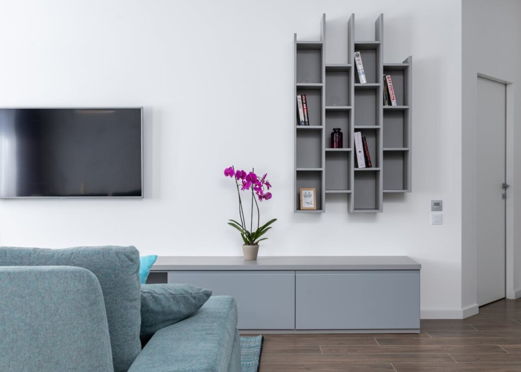 A grey and white living room with a purple orchid