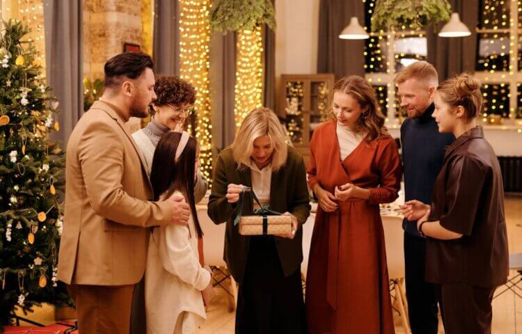 A family watching a mother open a Christmas gift