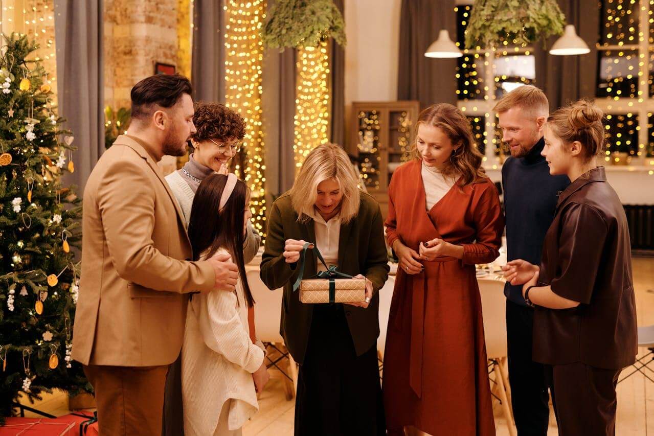 A family watching a mother open a Christmas gift